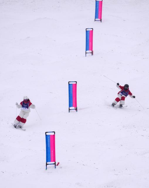 (260214) -- LIVIGNO, Feb. 14, 2026 (Xinhua) -- Li Ruilin (R) of China and Ashley Koehler of Canada compete during the freestyle skiing women's dual moguls 1/16 finals at the Milan-Cortina 2026 Olympic Winter Games in Livigno, Italy, Feb. 14, 2026. (Xinhua/Hu Chao)