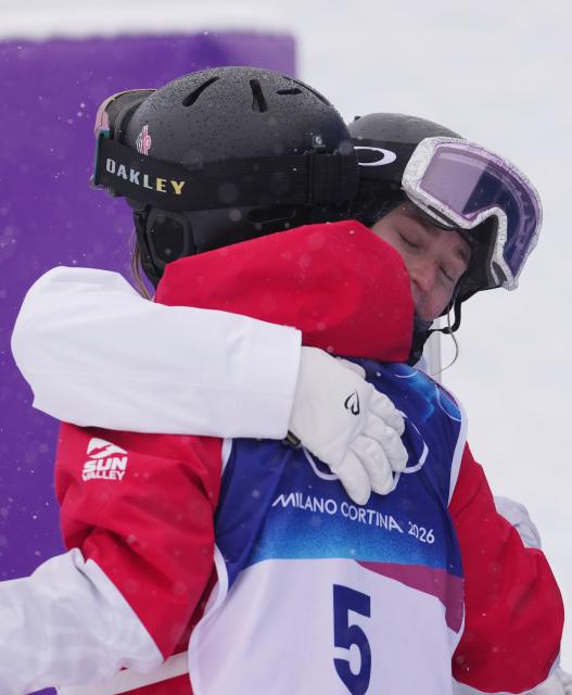 (260214) -- LIVIGNO, Feb. 14, 2026 (Xinhua) -- Elizabeth Lemley (back) of the United States hugs Perrine Laffont of France after winning the freestyle skiing women's dual moguls small final at the Milan-Cortina 2026 Olympic Winter Games in Livigno, Italy, Feb. 14, 2026. (Xinhua/Hu Chao)