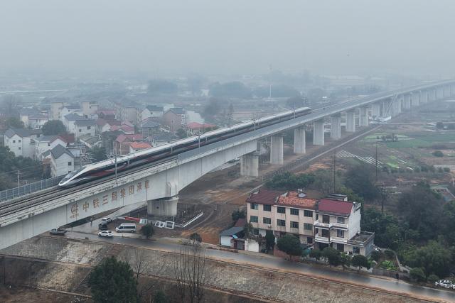 (260214) -- LANXI, Feb. 14, 2026 (Xinhua) -- This aerial drone photo taken on Feb. 14, 2026 shows a bullet train running on Lanjiang River grand bridge along the Lanxi-Jiande section of a high-speed railway in east China's Zhejiang Province. The Lanxi-Jiande section of a 64.51-kilometer high-speed railway linking cities of Jinhua and Jiande, both in east China's Zhejiang, was officially put into operation on Saturday. (Xinhua/Huang Zongzhi)