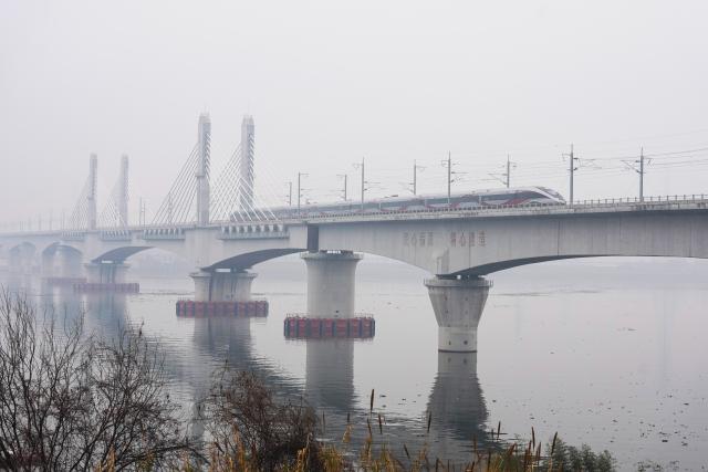 (260214) -- LANXI, Feb. 14, 2026 (Xinhua) -- This photo taken on Feb. 14, 2026 shows a bullet train running on Lanjiang River grand bridge along the Lanxi-Jiande section of a high-speed railway in east China's Zhejiang Province. The Lanxi-Jiande section of a 64.51-kilometer high-speed railway linking cities of Jinhua and Jiande, both in east China's Zhejiang, was officially put into operation on Saturday. (Xinhua/Huang Zongzhi)