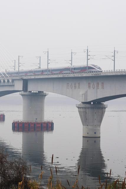 (260214) -- LANXI, Feb. 14, 2026 (Xinhua) -- This photo taken on Feb. 14, 2026 shows a bullet train running on Lanjiang River grand bridge along the Lanxi-Jiande section of a high-speed railway in east China's Zhejiang Province. The Lanxi-Jiande section of a 64.51-kilometer high-speed railway linking cities of Jinhua and Jiande, both in east China's Zhejiang, was officially put into operation on Saturday. (Xinhua/Huang Zongzhi)
