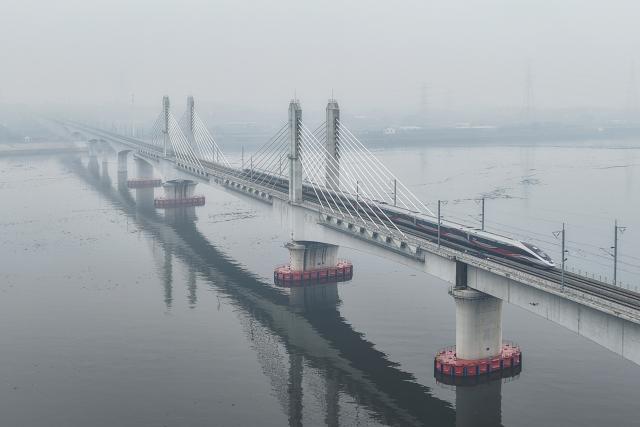 (260214) -- LANXI, Feb. 14, 2026 (Xinhua) -- This aerial drone photo taken on Feb. 14, 2026 shows a bullet train running on Lanjiang River grand bridge along the Lanxi-Jiande section of a high-speed railway in east China's Zhejiang Province. The Lanxi-Jiande section of a 64.51-kilometer high-speed railway linking cities of Jinhua and Jiande, both in east China's Zhejiang, was officially put into operation on Saturday. (Xinhua/Huang Zongzhi)