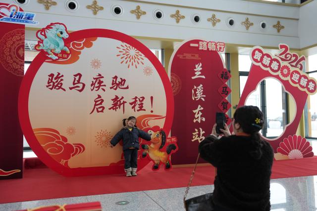 (260214) -- LANXI, Feb. 14, 2026 (Xinhua) -- A girl poses for photos at Lanxi East Railway Station in Lanxi, east China's Zhejiang Province, Feb. 14, 2026. The Lanxi-Jiande section of a 64.51-kilometer high-speed railway linking cities of Jinhua and Jiande, both in east China's Zhejiang, was officially put into operation on Saturday. (Xinhua/Huang Zongzhi)