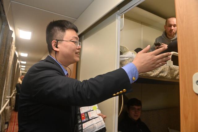 (260214) -- NANNING, Feb. 14, 2026 (Xinhua) -- A crew member offers ticket changing service for passengers onboard a China-Vietnam international passenger train at Pingxiang Station in Pingxiang City, south China's Guangxi Zhuang Autonomous Region, Feb. 11, 2026.
  Since its resumption on May 25, 2025, the China-Vietnam international passenger train has operated approximately 200 round trips by the end of 2025, transporting nearly 20,000 passengers while significantly boosting travel between the two countries.
   During the 2026 Spring Festival, every train on the rail service has been fully booked, with seat occupancy rate at its maximum. (Xinhua/Lu Boan)