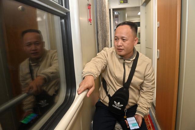(260214) -- NANNING, Feb. 14, 2026 (Xinhua) -- A passenger heading for Nanning in south China's Guangxi Zhuang Autonomous Region is seen onboard a China-Vietnam international passenger train on Feb. 11, 2026.
  Since its resumption on May 25, 2025, the China-Vietnam international passenger train has operated approximately 200 round trips by the end of 2025, transporting nearly 20,000 passengers while significantly boosting travel between the two countries.
   During the 2026 Spring Festival, every train on the rail service has been fully booked, with seat occupancy rate at its maximum. (Xinhua/Lu Boan)