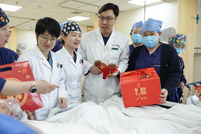 (260214) -- BEIJING, Feb. 14, 2026 (Xinhua) -- At 12:31 p.m. on Feb. 12, 2026: staff members celebrate the birthday of a nonagenarian patient in an emergency observation room of the Emergency Department in Guang'anmen Hospital in Beijing, capital of China. With the Spring Festival just around the corner, the staff members at the Emergency Department of Guang'anmen Hospital remain on duty around the clock. Racing against time, they are fully committed to protect the health of patients.
   As a national-level emergency center which integrates Traditional Chinese Medicine and Western medicine, the Emergency Department of Guang'anmen Hospital was founded over 40 years ago. Generations of medical practitioners have carried forward the wisdom of Traditional Chinese Medicine while keeping pace with modern emergency rescue. They are not only proficient in using advanced emergency equipment such as Extracorporeal Membrane Oxygenation (ECMO) and ultrasound diagnostic instruments to rescue critically ill patients, but also provide patients with precise and effective characteristic diagnosis and treatment, featuring over 30 hospital-agreed prescriptions and more than 20 external treatment methods of Traditional Chinese Medicine. (Xinhua/Zhang Yuwei)