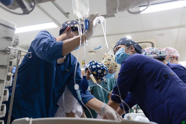 (260214) -- BEIJING, Feb. 14, 2026 (Xinhua) -- At 3:05 a.m. on Feb. 4, 2026: the on-duty nurses in the intensive care unit (ICU) receive a postoperative patient in the Emergency Department of Guang'anmen Hospital in Beijing, capital of China. With the Spring Festival just around the corner, the staff members at the Emergency Department of Guang'anmen Hospital remain on duty around the clock. Racing against time, they are fully committed to protect the health of patients.
   As a national-level emergency center which integrates Traditional Chinese Medicine and Western medicine, the Emergency Department of Guang'anmen Hospital was founded over 40 years ago. Generations of medical practitioners have carried forward the wisdom of Traditional Chinese Medicine while keeping pace with modern emergency rescue. They are not only proficient in using advanced emergency equipment such as Extracorporeal Membrane Oxygenation (ECMO) and ultrasound diagnostic instruments to rescue critically ill patients, but also provide patients with precise and effective characteristic diagnosis and treatment, featuring over 30 hospital-agreed prescriptions and more than 20 external treatment methods of Traditional Chinese Medicine. (Xinhua/Wang Jingqiang)