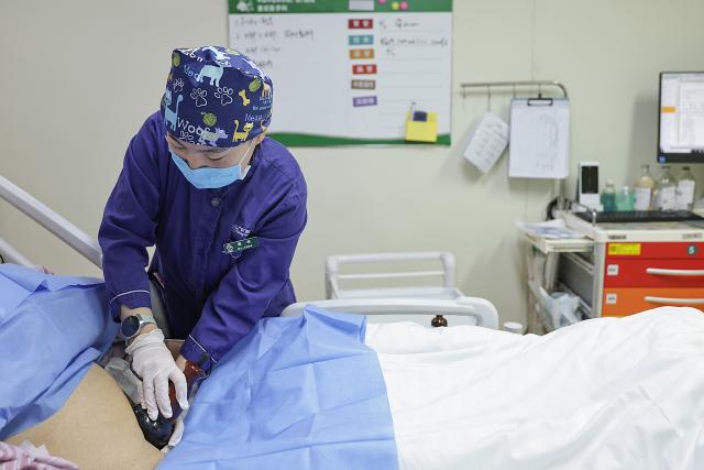 (260214) -- BEIJING, Feb. 14, 2026 (Xinhua) -- At 11:18 a.m. on Feb. 12, 2026: a nurse treats a patient in the intensive care unit (ICU) in the Emergency Department of Guang'anmen Hospital in Beijing, capital of China. With the Spring Festival just around the corner, the staff members at the Emergency Department of Guang'anmen Hospital remain on duty around the clock. Racing against time, they are fully committed to protect the health of patients.
   As a national-level emergency center which integrates Traditional Chinese Medicine and Western medicine, the Emergency Department of Guang'anmen Hospital was founded over 40 years ago. Generations of medical practitioners have carried forward the wisdom of Traditional Chinese Medicine while keeping pace with modern emergency rescue. They are not only proficient in using advanced emergency equipment such as Extracorporeal Membrane Oxygenation (ECMO) and ultrasound diagnostic instruments to rescue critically ill patients, but also provide patients with precise and effective characteristic diagnosis and treatment, featuring over 30 hospital-agreed prescriptions and more than 20 external treatment methods of Traditional Chinese Medicine. (Xinhua/Zhang Yuwei)