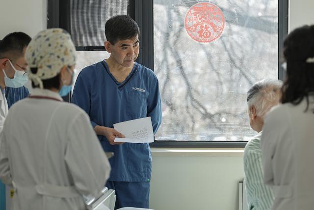 (260214) -- BEIJING, Feb. 14, 2026 (Xinhua) -- At 10:16 a.m. on Feb. 9, 2026: senior doctor Qi Wensheng (C) checks the condition of a patient in a ward in the Emergency Department of Guang'anmen Hospital in Beijing, capital of China. With the Spring Festival just around the corner, the staff members at the Emergency Department of Guang'anmen Hospital remain on duty around the clock. Racing against time, they are fully committed to protect the health of patients.
   As a national-level emergency center which integrates Traditional Chinese Medicine and Western medicine, the Emergency Department of Guang'anmen Hospital was founded over 40 years ago. Generations of medical practitioners have carried forward the wisdom of Traditional Chinese Medicine while keeping pace with modern emergency rescue. They are not only proficient in using advanced emergency equipment such as Extracorporeal Membrane Oxygenation (ECMO) and ultrasound diagnostic instruments to rescue critically ill patients, but also provide patients with precise and effective characteristic diagnosis and treatment, featuring over 30 hospital-agreed prescriptions and more than 20 external treatment methods of Traditional Chinese Medicine. (Xinhua/Zhang Yuwei)