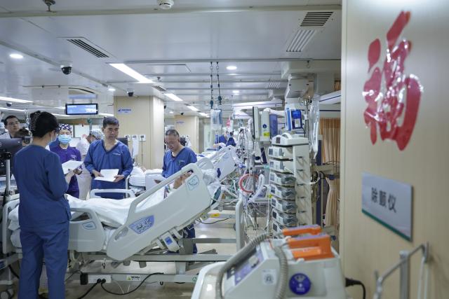 (260214) -- BEIJING, Feb. 14, 2026 (Xinhua) -- At 8:31 a.m. on Feb. 9, 2026: senior doctor Qi Wensheng (2nd R) checks the condition of a patient in the intensive care unit (ICU) in the Emergency Department of Guang'anmen Hospital in Beijing, capital of China. With the Spring Festival just around the corner, the staff members at the Emergency Department of Guang'anmen Hospital remain on duty around the clock. Racing against time, they are fully committed to protect the health of patients.
   As a national-level emergency center which integrates Traditional Chinese Medicine and Western medicine, the Emergency Department of Guang'anmen Hospital was founded over 40 years ago. Generations of medical practitioners have carried forward the wisdom of Traditional Chinese Medicine while keeping pace with modern emergency rescue. They are not only proficient in using advanced emergency equipment such as Extracorporeal Membrane Oxygenation (ECMO) and ultrasound diagnostic instruments to rescue critically ill patients, but also provide patients with precise and effective characteristic diagnosis and treatment, featuring over 30 hospital-agreed prescriptions and more than 20 external treatment methods of Traditional Chinese Medicine. (Xinhua/Zhang Yuwei)