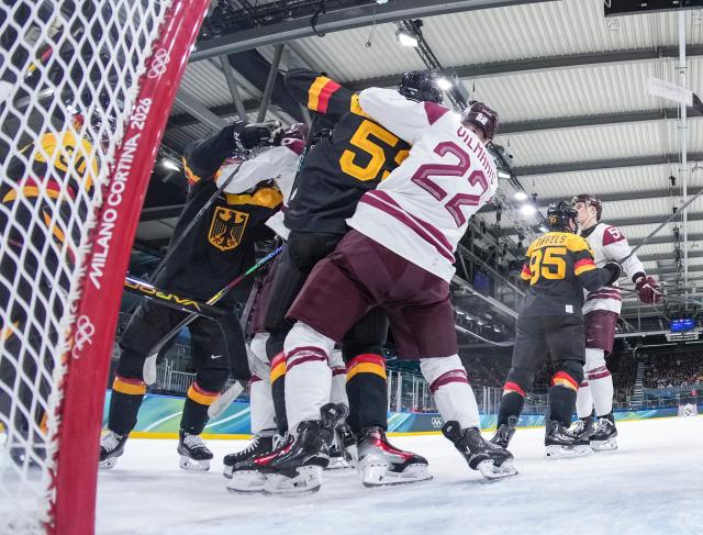(260214) -- MILAN, Feb. 14, 2026 (Xinhua) -- Players of both teams fight during the ice hockey men's preliminary round group C match between Germany and Latvia of the Milan-Cortina 2026 Olympic Winter Games in Milan, Italy, Feb. 14, 2026. (Sun Fei/Pool via Xinhua)