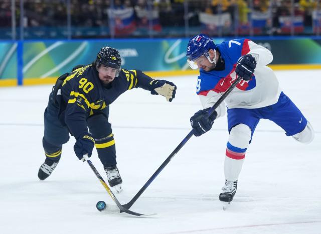 (260214) -- MILAN, Feb. 14, 2026 (Xinhua) -- Libor Hudacek (R) of Slovakia and Marcus Johansson of Sweden vie for the puck during the ice hockey men's preliminary round group B match between Sweden and Slovakia of the Milan-Cortina 2026 Olympic Winter Games in Milan, Italy, Feb. 14, 2026. (Xinhua/Tao Xiyi)