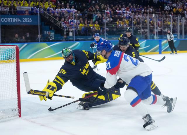 (260214) -- MILAN, Feb. 14, 2026 (Xinhua) -- Adam Ruzicka (2nd L) of Slovakia shoots during the ice hockey men's preliminary round group B match between Sweden and Slovakia of the Milan-Cortina 2026 Olympic Winter Games in Milan, Italy, Feb. 14, 2026. (Xinhua/Tao Xiyi)