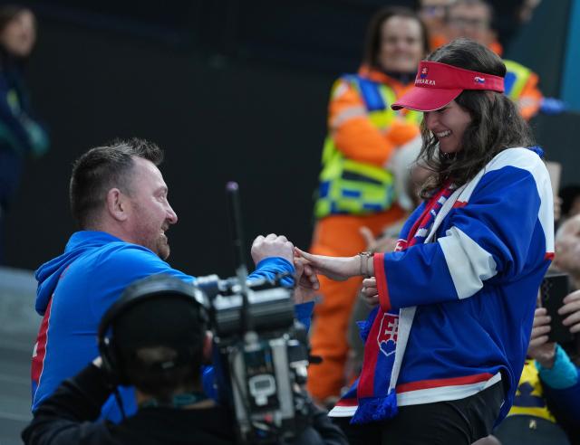 (260214) -- MILAN, Feb. 14, 2026 (Xinhua) -- A fan of Slovakia proposes to his girlfriend during the ice hockey men's preliminary round group B match between Sweden and Slovakia of the Milan-Cortina 2026 Olympic Winter Games in Milan, Italy, Feb. 14, 2026. (Xinhua/Tao Xiyi)