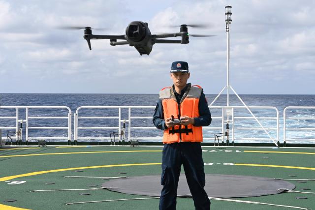 (260214) -- SOUTH CHINA SEA, Feb. 14, 2026 (Xinhua) -- Law enforcer Qiu Canhui operates a drone aboard the China Coast Guard (CCG) vessel Wanshan in the territorial waters of China's Huangyan Dao, Feb. 11, 2026. Right ahead of the Chinese New Year, a traditional occasion for family reunion in China, a group of young law enforcers remain loyally stationed and highly alert around the clock, hundreds of miles away from their loved ones. (Photo by Zhai Yifan/Xinhua)