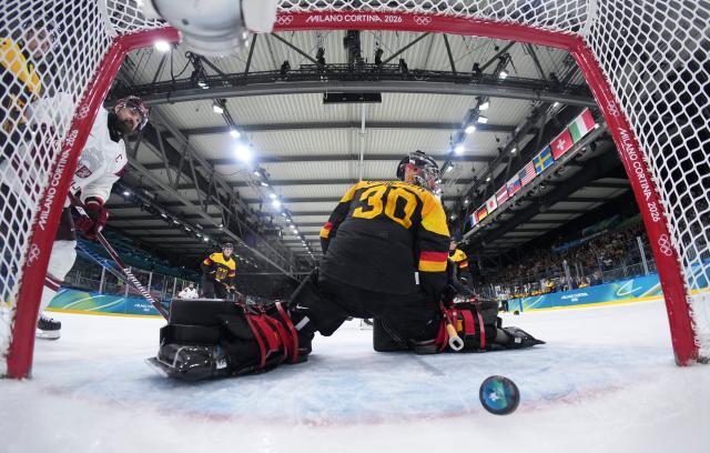 (260214) -- MILAN, Feb. 14, 2026 (Xinhua) -- Philipp Grubauer (front), goalkeeper of Germany fails to make a save during the ice hockey men's preliminary round group C match between Germany and Latvia of the Milan-Cortina 2026 Olympic Winter Games in Milan, Italy, Feb. 14, 2026. (Sun Fei/Pool via Xinhua)