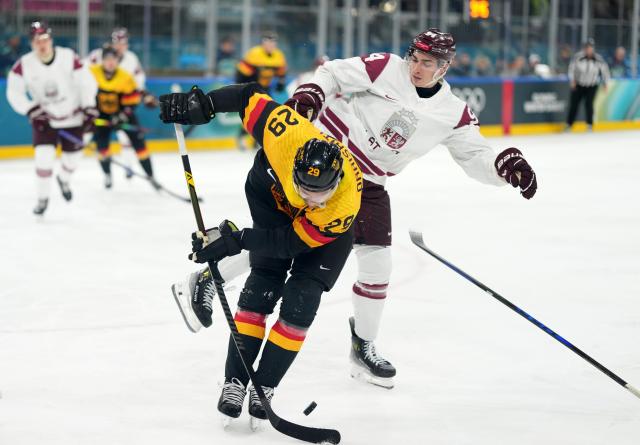 (260214) -- MILAN, Feb. 14, 2026 (Xinhua) -- Leon Draisaitl (L) of Germany and Kristians Rubins of Latvia battle for the puck during the ice hockey men's preliminary round group C match between Germany and Latvia of the Milan-Cortina 2026 Olympic Winter Games in Milan, Italy, Feb. 14, 2026. (Xinhua/Sun Fei)
