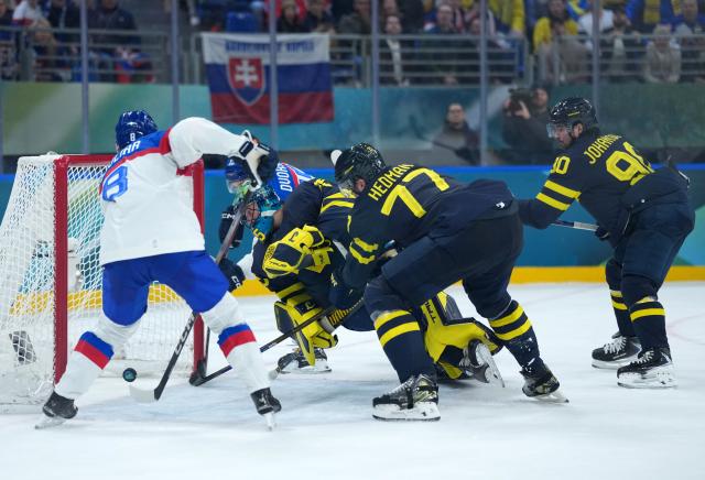 (260214) -- MILAN, Feb. 14, 2026 (Xinhua) -- Players of both teams compete during the ice hockey men's preliminary round group B match between Sweden and Slovakia of the Milan-Cortina 2026 Olympic Winter Games in Milan, Italy, Feb. 14, 2026. (Xinhua/Tao Xiyi)