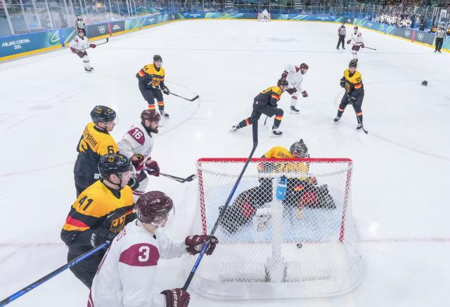 (260214) -- MILAN, Feb. 14, 2026 (Xinhua) -- Philipp Grubauer (bottom C), goalkeeper of Germany fails to make a save during the ice hockey men's preliminary round group C match between Germany and Latvia of the Milan-Cortina 2026 Olympic Winter Games in Milan, Italy, Feb. 14, 2026. (Xinhua/Sun Fei)