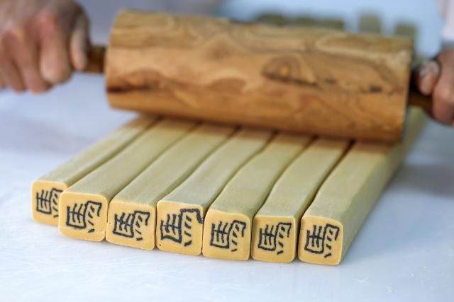 (260214) -- HEFEI, Feb. 14, 2026 (Xinhua) -- A staff member makes character-inlaid candies in Qimen County of Huangshan City, east China's Anhui Province, Jan. 13, 2026.
  As the Spring Festival approaches, inheritors of the making crafts of character-inlaid candy, an intangible cultural heritage in Qimen County, are getting busy as this specialty sweet is highly sought for during the festival. 
   The making process of the candy includes boiling sugar, grinding powder, stirring, compacting, making inlaid characters, stretching sugar bar and slicing. Because the character embedded in the center of the candy always carries auspicious meanings, such candy is very popular during festivals.
   Candies inlaid with Chinese character "Ma," referring to the horse, are the most popular now, as this Spring Festival will usher in the Year of the Horse. (Xinhua/Zhou Mu)