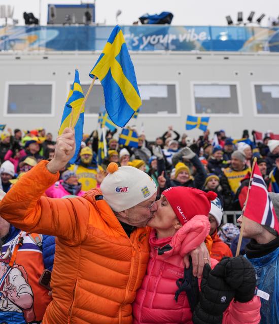(260214) -- TESERO, Feb. 14, 2026 (Xinhua) -- Spectators kiss during the cross-country skiing women's 4x7.5km relay match at the Milan-Cortina 2026 Olympic Winter Games in Tesero, Italy, Feb. 14, 2026. (Xinhua/Peng Ziyang)