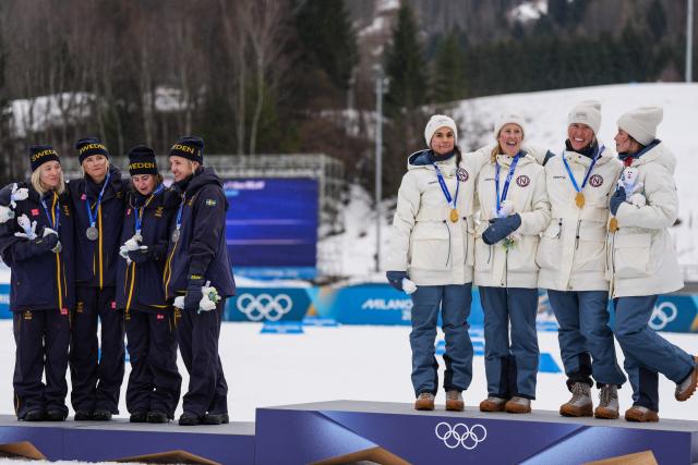 (260214) -- TESERO, Feb. 14, 2026 (Xinhua) -- Kristin Austgulen Fosnaes, Astrid Oeyre Slind, Karoline Simpson-Larsen and Heidi Weng of Norway, and Linn Svahn, Ebba Andersson, Frida Karlsson and Jonna Sundling of Sweden attend the awarding ceremony of the cross-country skiing women's 4x7.5km relay match at the Milan-Cortina 2026 Olympic Winter Games in Tesero, Italy, Feb. 14, 2026. (Xinhua/Peng Ziyang)