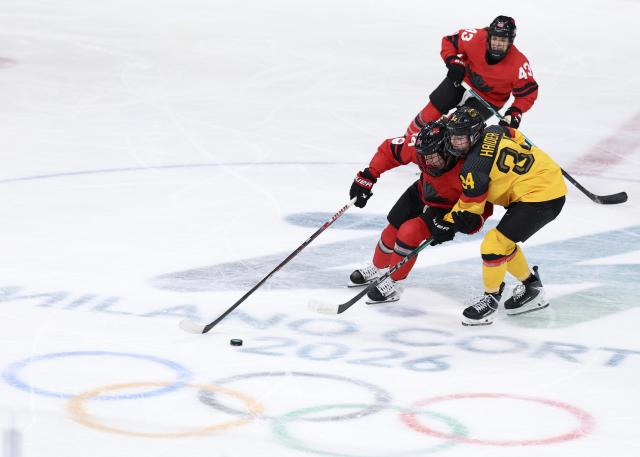 (260214) -- MILAN, Feb. 14, 2026 (Xinhua) -- Jennifer Gardiner of Canada (L, front) vies with Celina Haider of Germany during the ice hockey women's play-offs quarterfinal between Canada and Germany at the Milan-Cortina 2026 Olympic Winter Games in Milan, Italy, Feb. 14, 2026. (Xinhua/Wang Kaiyan)