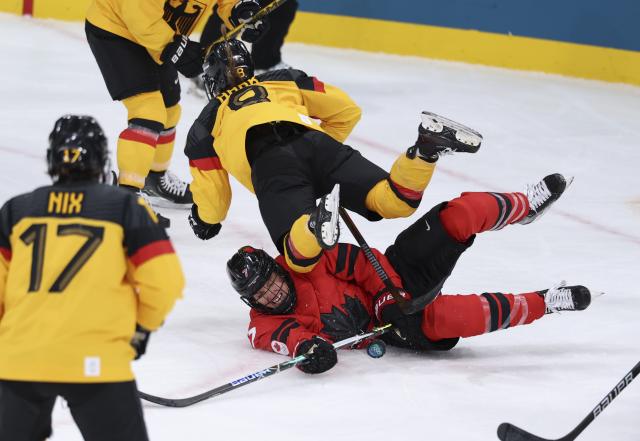 (260214) -- MILAN, Feb. 14, 2026 (Xinhua) -- Laura Stacey (bottom) of Canada competes with Ronja Hark of Germany during the ice hockey women's play-offs quarterfinal between Canada and Germany at the Milan-Cortina 2026 Olympic Winter Games in Milan, Italy, Feb. 14, 2026. (Xinhua/Wang Kaiyan)
