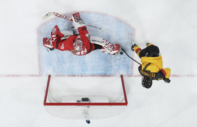(260214) -- MILAN, Feb. 14, 2026 (Xinhua) -- Franziska Feldmeier (R) of Germany shoots during the ice hockey women's play-offs quarterfinal between Canada and Germany at the Milan-Cortina 2026 Olympic Winter Games in Milan, Italy, Feb. 14, 2026. (Xinhua/Sun Fei)