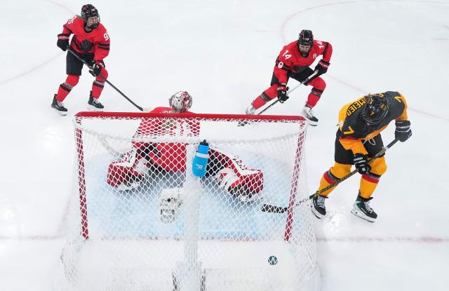 (260214) -- MILAN, Feb. 14, 2026 (Xinhua) -- Franziska Feldmeier (1st R) of Germany shoots during the ice hockey women's play-offs quarterfinal between Canada and Germany at the Milan-Cortina 2026 Olympic Winter Games in Milan, Italy, Feb. 14, 2026. (Xinhua/Sun Fei)