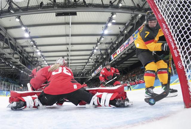 (260214) -- MILAN, Feb. 14, 2026 (Xinhua) -- Franziska Feldmeier (R) of Germany scores during the ice hockey women's play-offs quarterfinal between Canada and Germany at the Milan-Cortina 2026 Olympic Winter Games in Milan, Italy, Feb. 14, 2026. (Xinhua/Sun Fei)