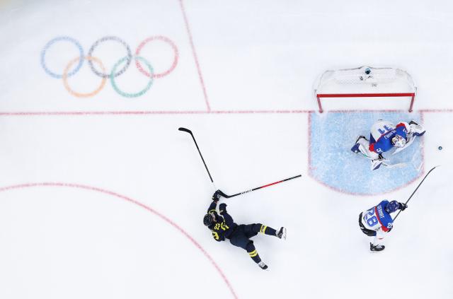 (260215) -- MILAN, Feb. 15, 2026 (Xinhua) -- Lucas Raymond (L) of Sweden falls during the ice hockey men's preliminary round group B match between Sweden and Slovakia of the Milan-Cortina 2026 Olympic Winter Games in Milan, Italy, Feb. 14, 2026. (Xinhua/Tao Xiyi)