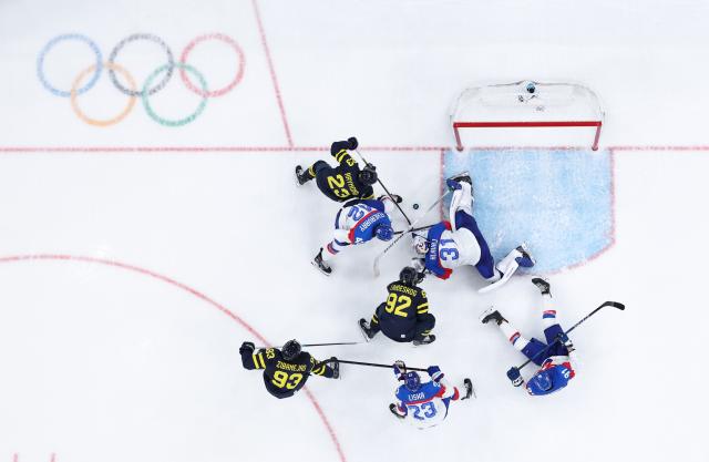 (260215) -- MILAN, Feb. 15, 2026 (Xinhua) -- Players compete during the ice hockey men's preliminary round group B match between Sweden and Slovakia of the Milan-Cortina 2026 Olympic Winter Games in Milan, Italy, Feb. 14, 2026. (Xinhua/Tao Xiyi)