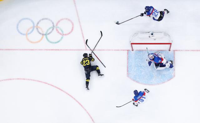 (260215) -- MILAN, Feb. 15, 2026 (Xinhua) -- Lucas Raymond (L) of Sweden falls during the ice hockey men's preliminary round group B match between Sweden and Slovakia of the Milan-Cortina 2026 Olympic Winter Games in Milan, Italy, Feb. 14, 2026. (Xinhua/Tao Xiyi)
