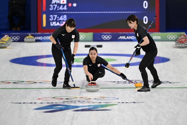 (260215) -- CORTINA D'AMPEZZO, Feb. 15, 2026 (Xinhua) -- Ohmiya Anna (C) of Japan competes during the curling women round robin session 5 match between Japan and the United States at the 2026 Milan-Cortina Winter Olympics in Cortina, Italy, Feb. 14, 2026. (Xinhua/Lian Yi)