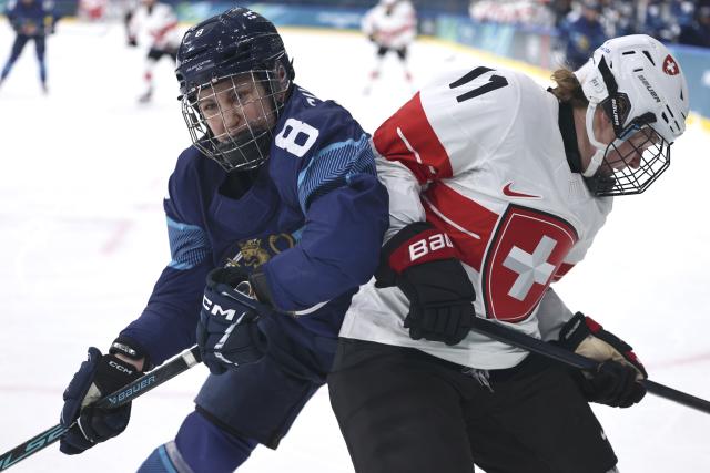 (260215) -- MILAN, Feb. 15, 2026 (Xinhua) -- Elli Suoranta (L) of Finland vies with Laura Zimmermann of Switzerland during the ice hockey women's play-offs quarterfinal between Finland and Switzerland at the Milan-Cortina 2026 Olympic Winter Games in Milan, Italy, Feb. 14, 2026. (Xinhua/Wang Kaiyan)