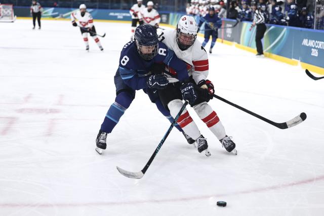 (260215) -- MILAN, Feb. 15, 2026 (Xinhua) -- Elli Suoranta (L) of Finland vies with Laura Zimmermann of Switzerland during the ice hockey women's play-offs quarterfinal between Finland and Switzerland at the Milan-Cortina 2026 Olympic Winter Games in Milan, Italy, Feb. 14, 2026. (Xinhua/Wang Kaiyan)