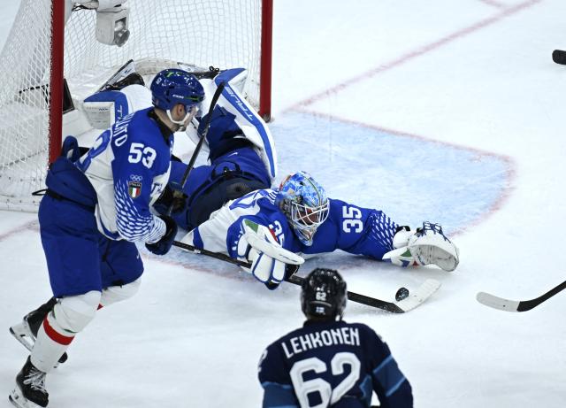 (260215) -- MILAN, Feb. 15, 2026 (Xinhua) -- Davide Fadani (R, top), goalkeeper of Italy, makes a save during the ice hockey men's preliminary round group B match between Italy and Finland of the Milan-Cortina 2026 Olympic Winter Games in Milan, Italy, Feb. 14, 2026. (Xinhua/Zhang Haofu)
