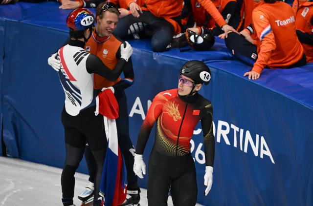 (260215) -- MILAN, Feb. 15, 2026 (Xinhua) -- Liu Shaoang (R) of China reacts after the short track speed skating men's 1500m final A at the Milan-Cortina 2026 Olympic Winter Games in Milan, Italy, Feb. 14, 2026. (Xinhua/Cheng Min)