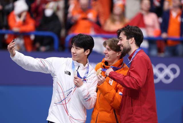 (260215) -- MILAN, Feb. 15, 2026 (Xinhua) -- Silver medalist Hwang Daeheon of South Korea, gold medalist Jens van 'T Wout of the Netherlands and bronze medalist Roberts Kruzbergs of Latvia (L to R) take selfies during the awarding ceremony of short track speed skating men's 1500m match at the Milan-Cortina 2026 Olympic Winter Games in Milan, Italy, Feb. 14, 2026. (Xinhua/Chen Yichen)