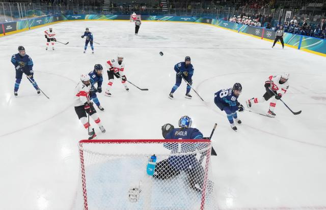 (260215) -- MILAN, Feb. 15, 2026 (Xinhua) -- Laure Meriguet (1st R) of Switzerland shoots during the ice hockey women's play-offs quarterfinals match between Finland and Switzerland of the Milan-Cortina 2026 Olympic Winter Games in Milan, Italy, Feb. 14, 2026. (Wang Kaiyan/Pool via Xinhua)