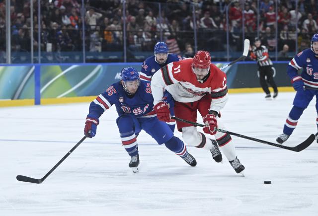 (260215) -- MILAN, Feb. 15, 2026 (Xinhua) -- Alexander True (R) of Denmark vies with Jake Sanderson (L) of the United States during the ice hockey men's preliminary round group C match between the United States and Denmark of the Milan-Cortina 2026 Olympic Winter Games in Milan, Italy, Feb. 14, 2026. (Xinhua/Zhang Haofu)