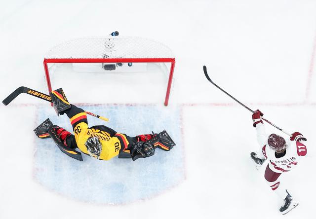 (260215) -- MILAN, Feb. 15, 2026 (Xinhua) -- Dans Locmelis (R) of Latvia scores during the ice hockey men's preliminary round group C match between Germany and Latvia of the Milan-Cortina 2026 Olympic Winter Games in Milan, Italy, Feb. 14, 2026. (Xinhua/Sun Fei)