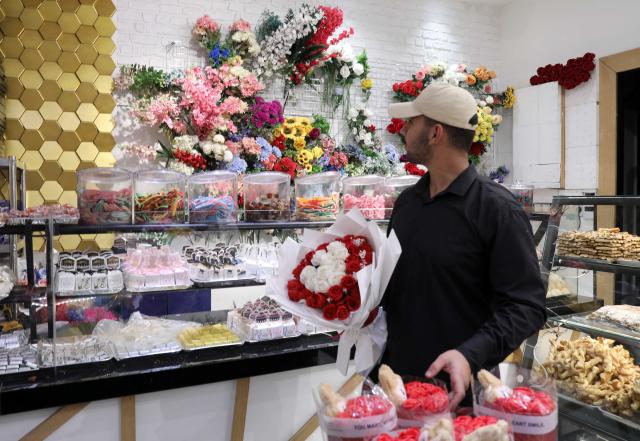 (260215) -- BAGHDAD, Feb. 15, 2026 (Xinhua) -- A man buys Valentine's Day flowers at a store in Baghdad, Iraq, on Feb. 14, 2026. (Xinhua/Khalil Dawood)