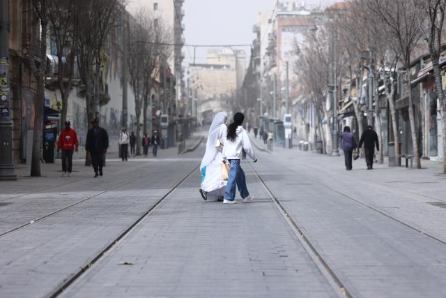 (260215) -- JERUSALEM, Feb. 15, 2026 (Xinhua) -- People walk during a dust storm in Jerusalem, Feb. 14, 2026. (Photo by Jamal Awad/Xinhua)