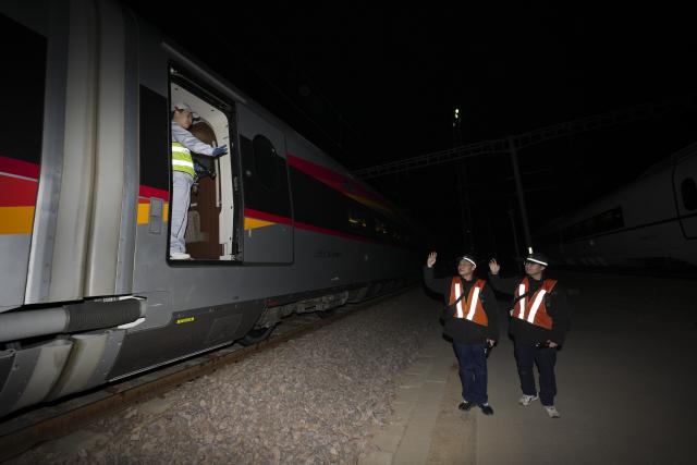 (260215) -- TAIYUAN, Feb. 15, 2026 (Xinhua) -- E Ming (L) greets to colleagues at a train depot in Yuci, north China's Shanxi Province, Feb. 14, 2026. Railway staff members have stepped up the maintenance of high-speed trains to ensure traffic safety during the Spring Festival travel rush.
E Ming is a service mechanic, responsible for inspecting and repairing onboard equipment such as seats, restrooms, and electric water boilers. During the Spring Festival travel rush, these facilities experience high usage and are prone to malfunctions. E Ming's team must work against the clock during the train's brief maintenance window at night to resolve equipment issues. (Xinhua/Yang Chenguang)