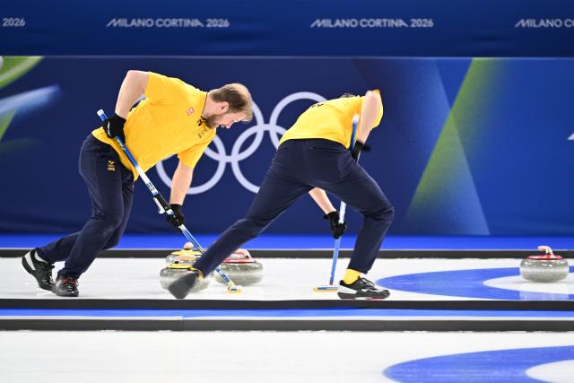 (260215) -- CORTINA D'AMPEZZO, Feb. 15, 2026 (Xinhua) -- Rasmus Wranaa (L) of Sweden competes during the curling men round robin session 6 match between the United States and Sweden at the 2026 Milan-Cortina Winter Olympics in Cortina, Italy, Feb. 15, 2026. (Xinhua/Lian Yi)