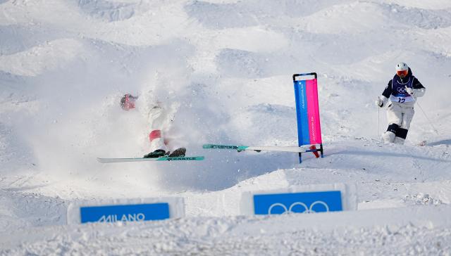 (260215) -- LIVIGNO, Feb. 15, 2026 (Xinhua) -- Julien Viel (L) of Canada falls during the freestyle skiing men's dual moguls 1/8 finals at the Milan-Cortina 2026 Olympic Winter Games in Livigno, Italy, Feb. 15, 2026. (Xinhua/Wu Huiwo)