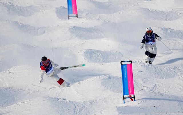 (260215) -- LIVIGNO, Feb. 15, 2026 (Xinhua) -- Julien Viel (L) of Canada falls during the freestyle skiing men's dual moguls 1/8 finals at the Milan-Cortina 2026 Olympic Winter Games in Livigno, Italy, Feb. 15, 2026. (Xinhua/Wu Huiwo)