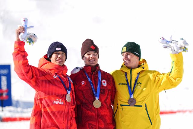 (260215) -- LIVIGNO, Feb. 15, 2026 (Xinhua) -- Gold medalist Mikael Kingsbury (C) of Canada, silver medalist Horishima Ikuma (L) of Japan and bronze medalist Matt Graham of Australia pose for photos during the awarding ceremony for the freestyle skiing men's dual moguls at the Milan-Cortina 2026 Olympic Winter Games in Livigno, Italy, Feb. 15, 2026. (Xinhua/Wu Huiwo)